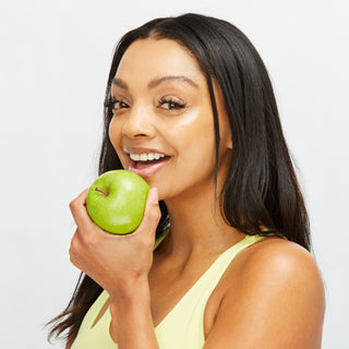Woman with Glowing Spring Skin Eating an Apple