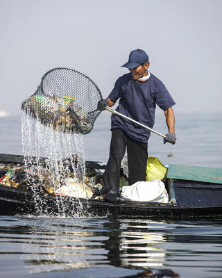 A Man Cleaning Plastic From the Ocean in a Kayak