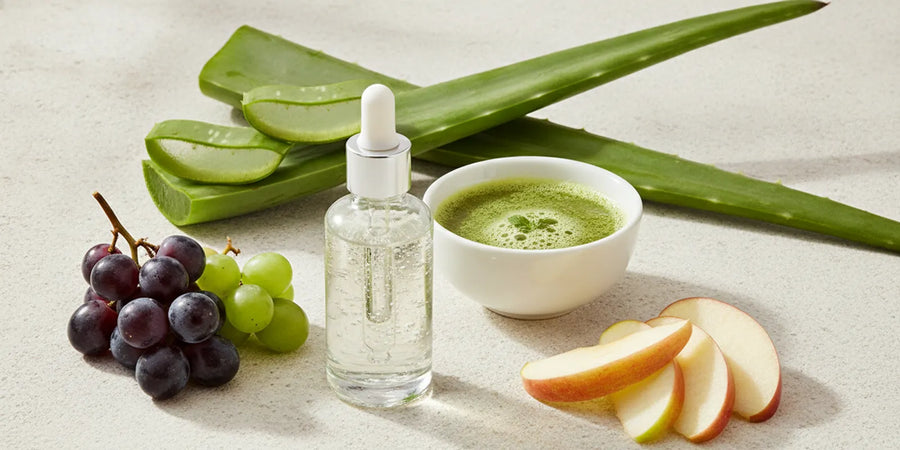 Organic botanical juices and a glass serum bottle arranged on a clean skincare counter
