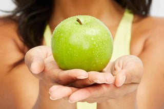 A Woman Holding a Green Apple in Her Hands